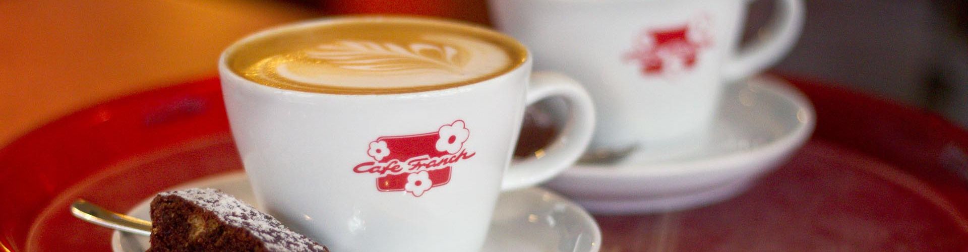 Kaffee in der Café-Franck-Tasse mit Kuchen – Originalfoto des Cafés